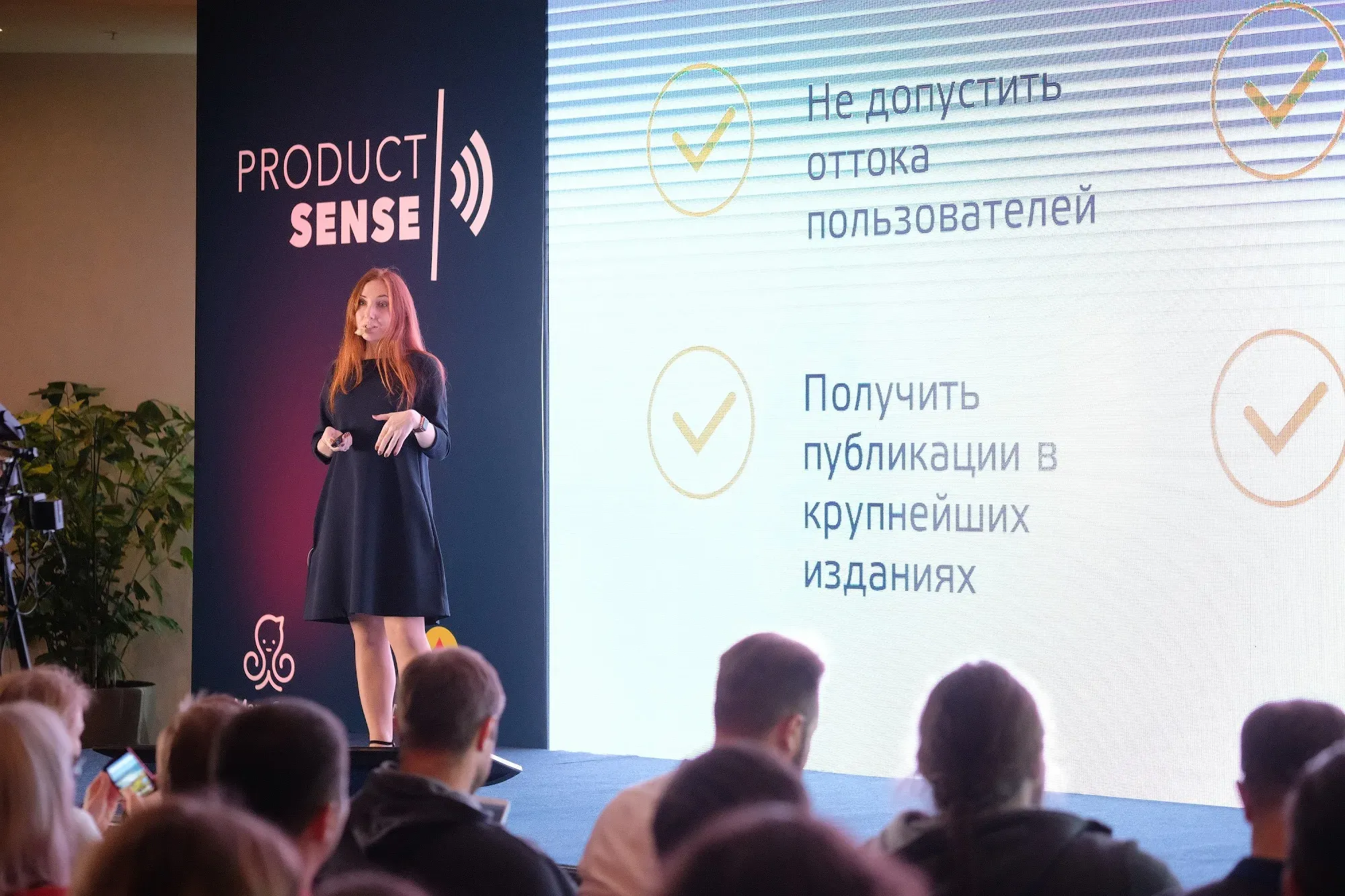 Nadia Nazarova speaking on stage at Product Sense, beside the conference banner